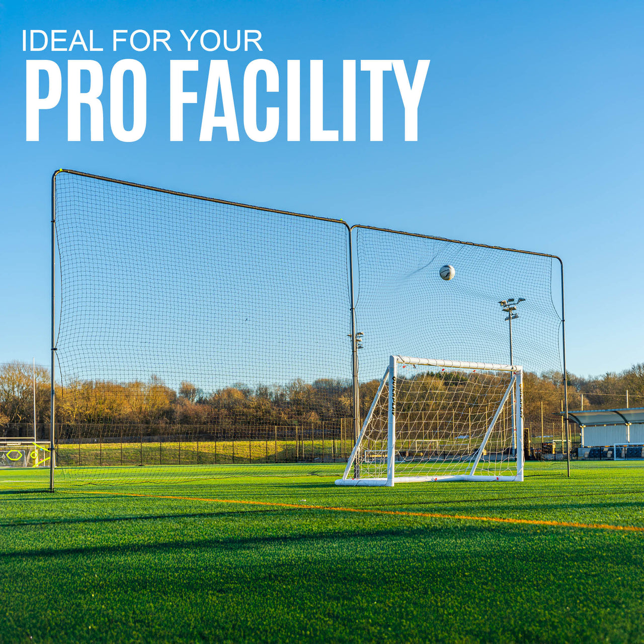 football goal on a sports field and a barrier net ball stop system behind it with clear blue sky and 'Ideal for your Pro Facility' text.