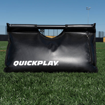 Black sand bag with 'QuickPlay' branding on a grass field.