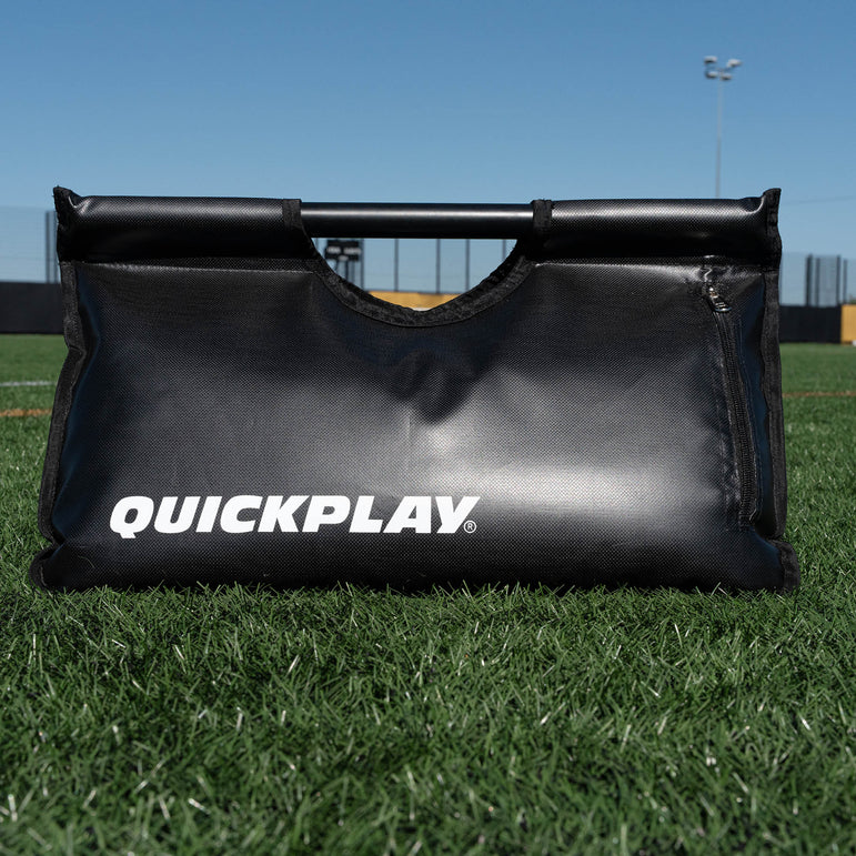 Black sand bag with 'QuickPlay' branding on a grass field.