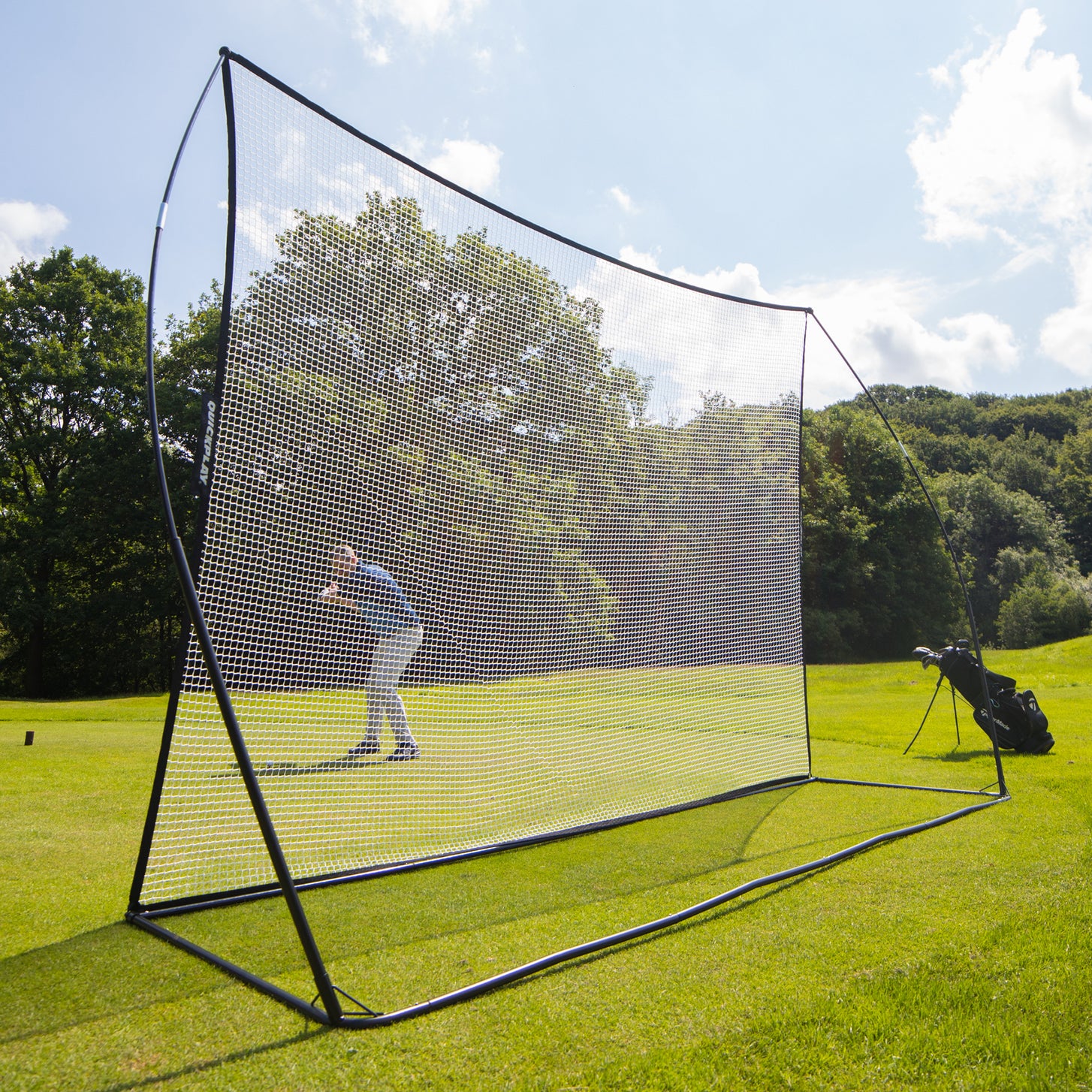 MEGA NET Golf Hitting Net 12x9' on a fairway seen from the front, with a golfer visible through the white net.