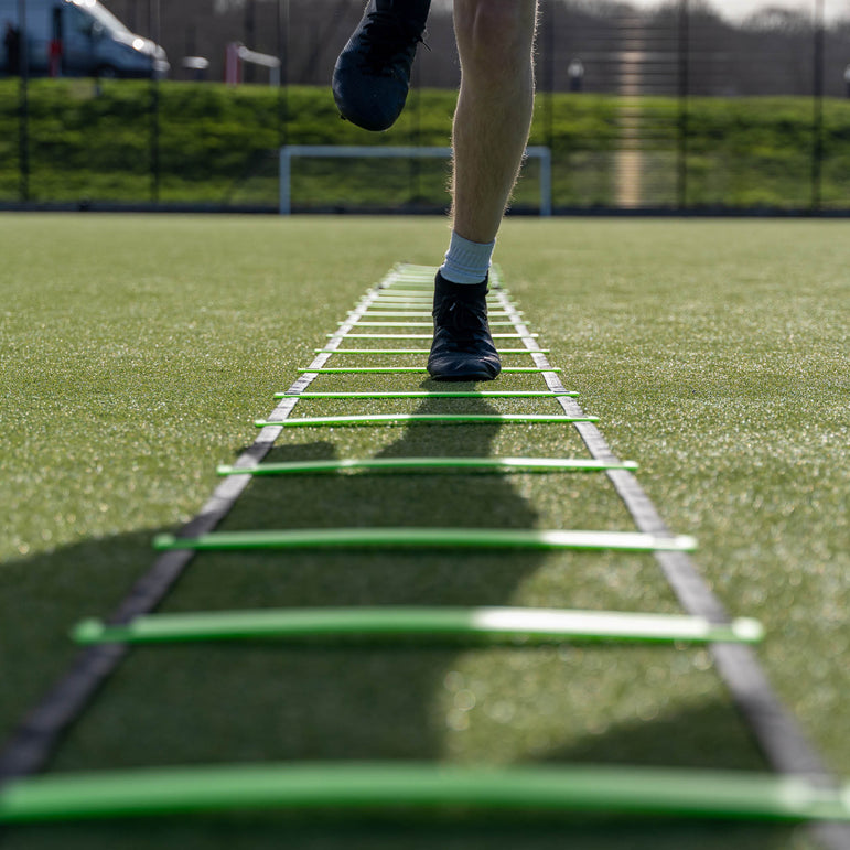 Person using a agility ladder on a sports field