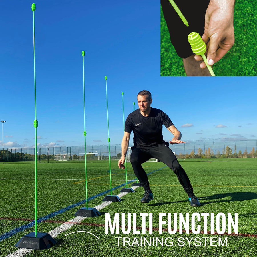 Person using a multi-function training system with green poles on a sports field.