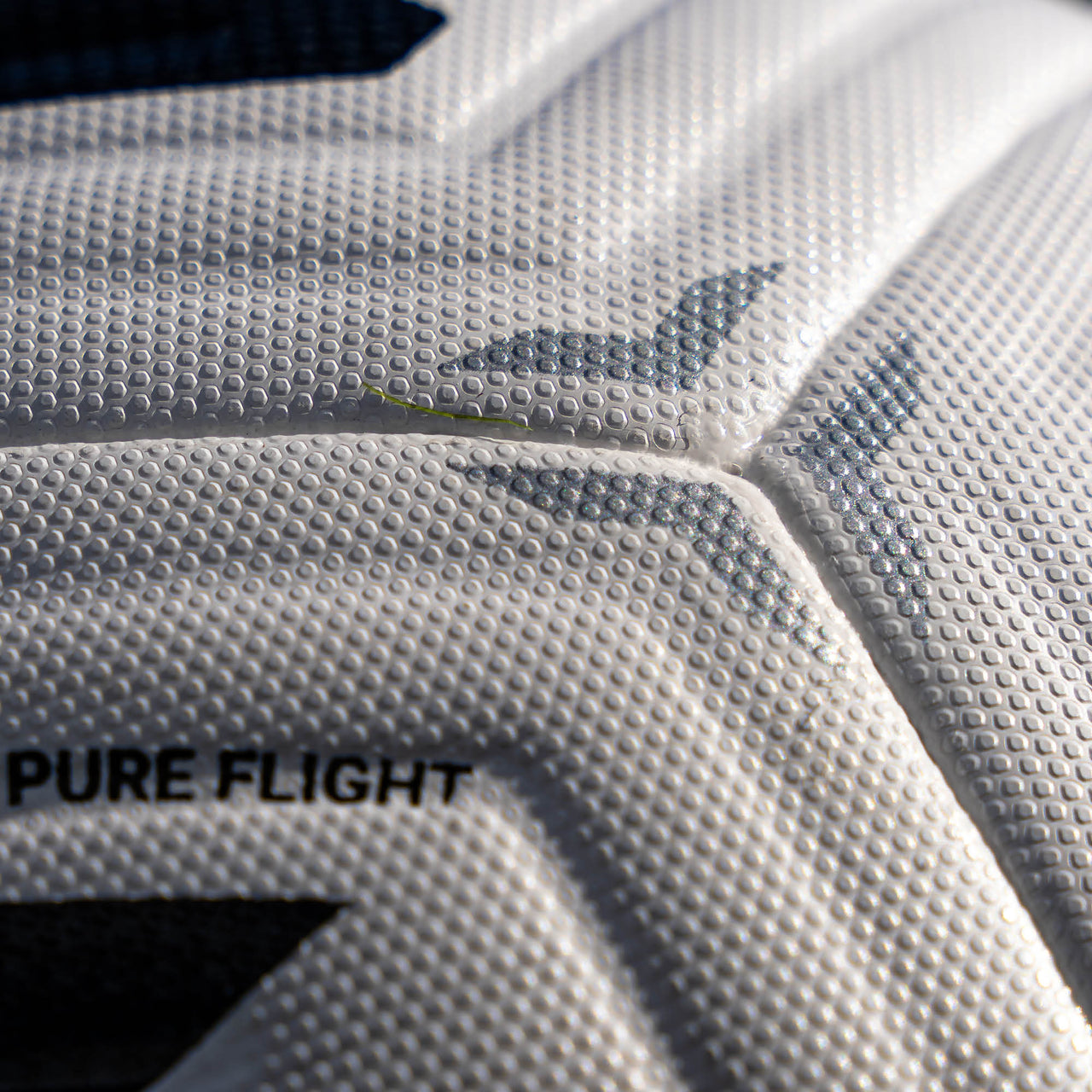 Close-up of a white football with 'PURE FLIGHT' text and brand logo.
