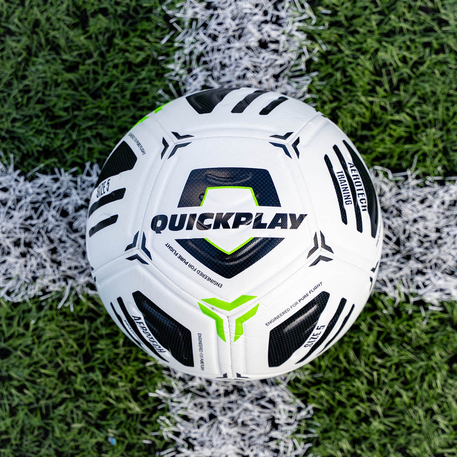 White football with black and green accents on a grass field, featuring the brand 'Quickplay'.