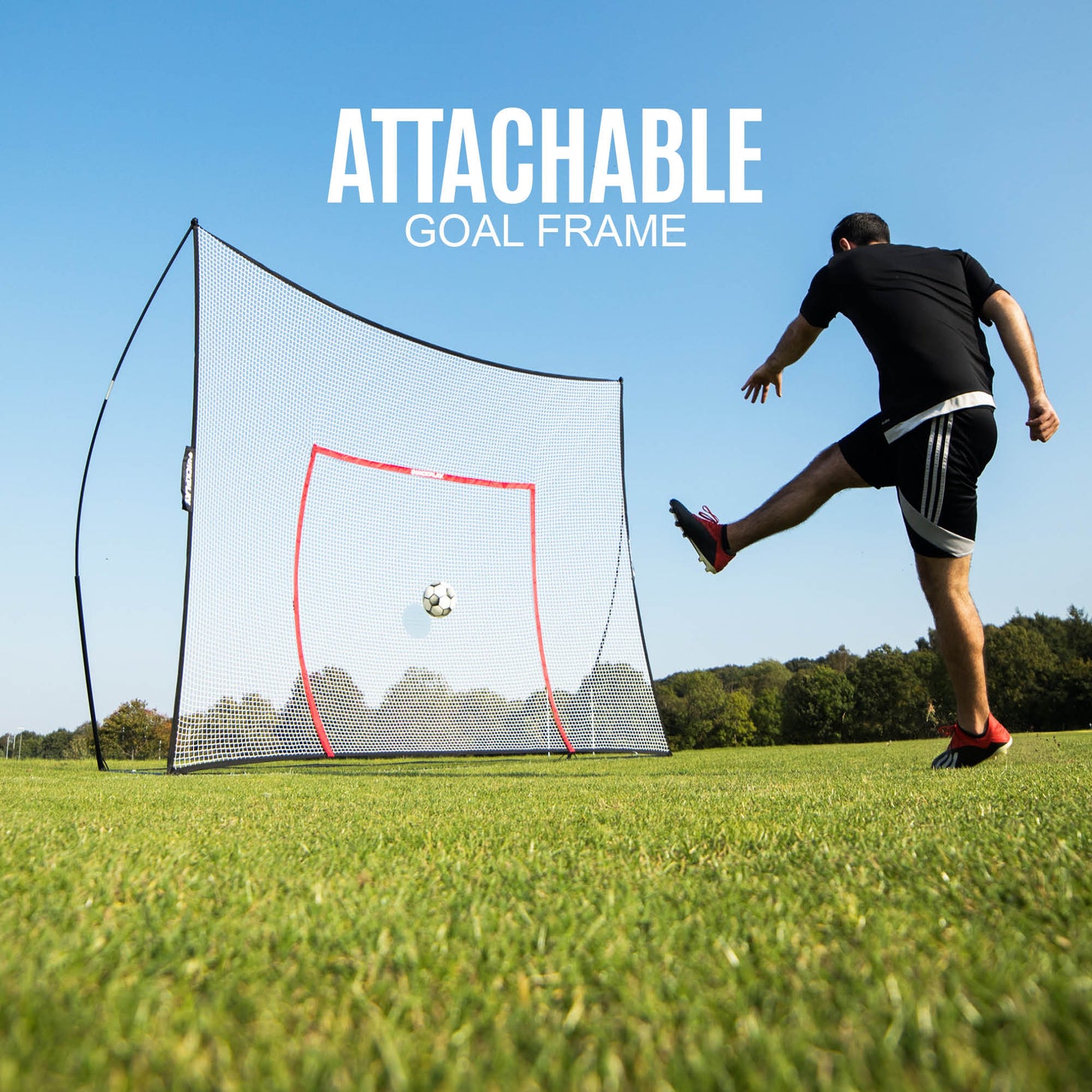Player striking a ball towards the orange target frame on the MEGA NET 12x9' ball-stop on grass, with the text "Attachable goal frame".