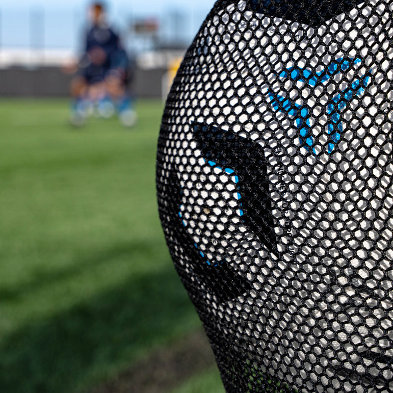 Close-up of a football bag on a blurred sports field background