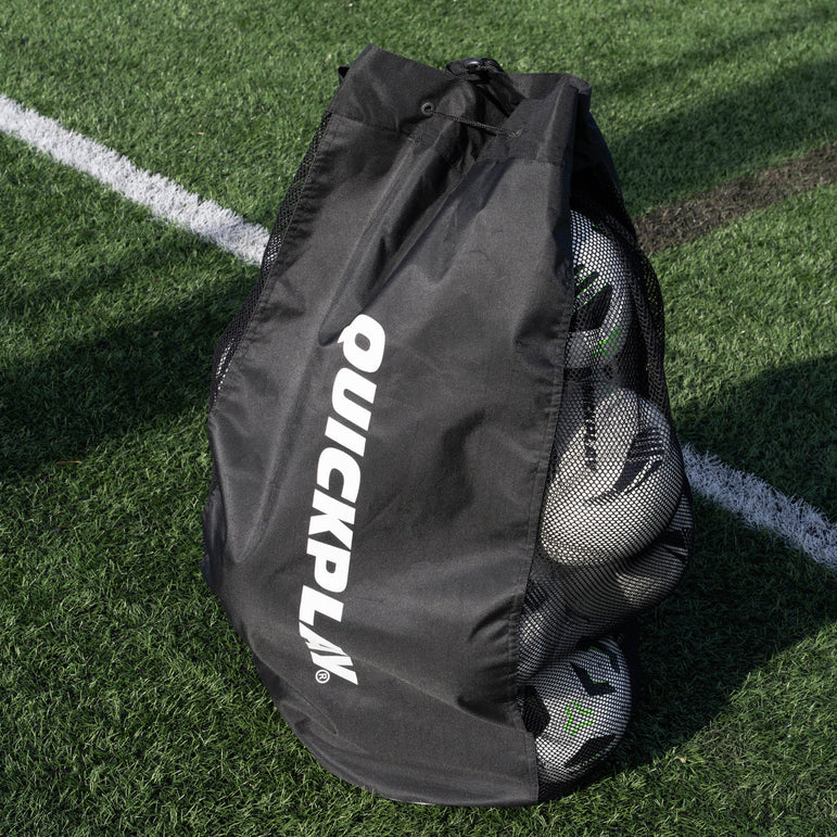 Black football bag with footballs on a grass field, featuring the QuickPlay brand.