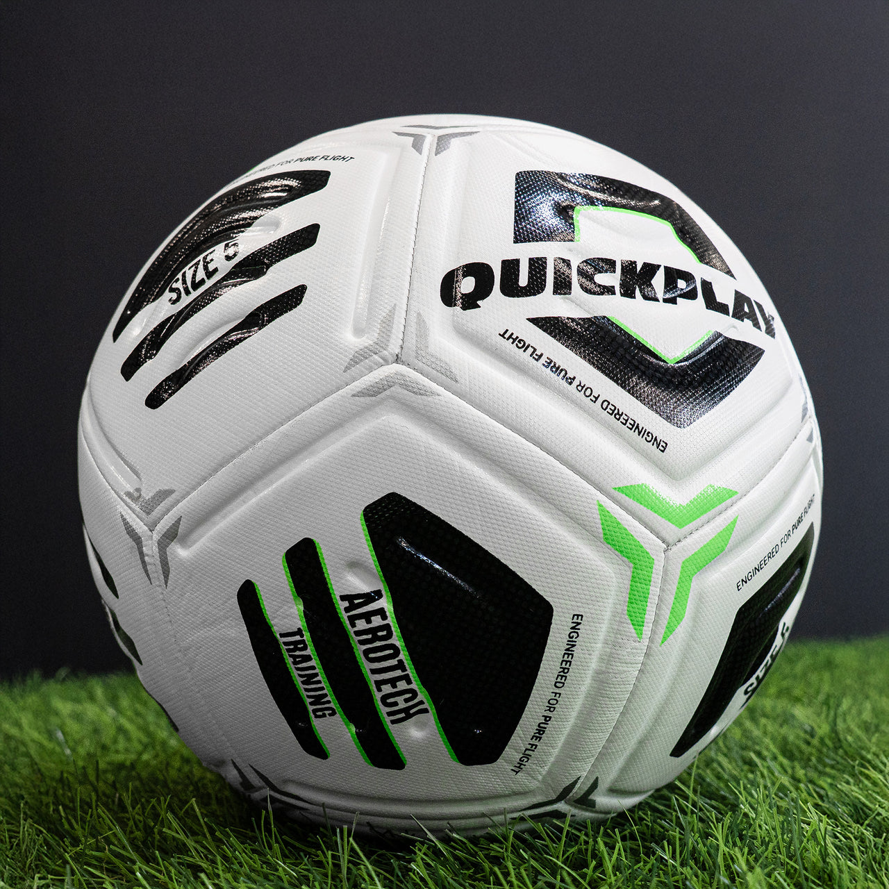 White Aerotech Training football with black and green branding on a grassy field