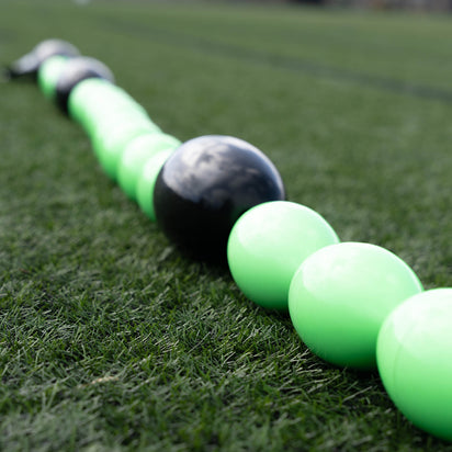 Green and black goalkeeper deflection line training equipment on grass