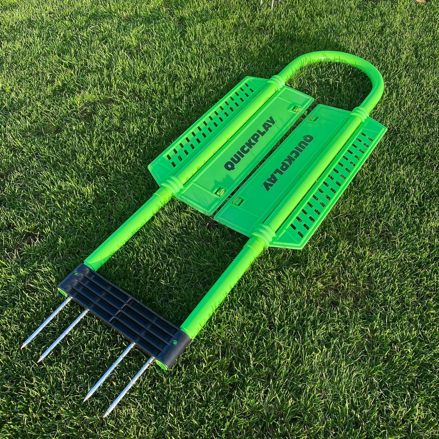 REPLAY Defender Mannequin lying flat on grass, showing the green frame, both body panels and the black base with metal spikes.