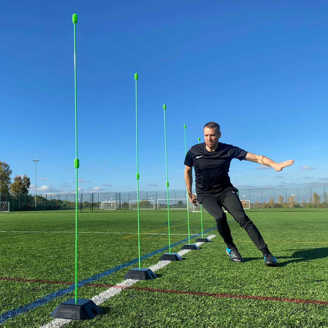 Person practicing agility drills with green markers on a sports field