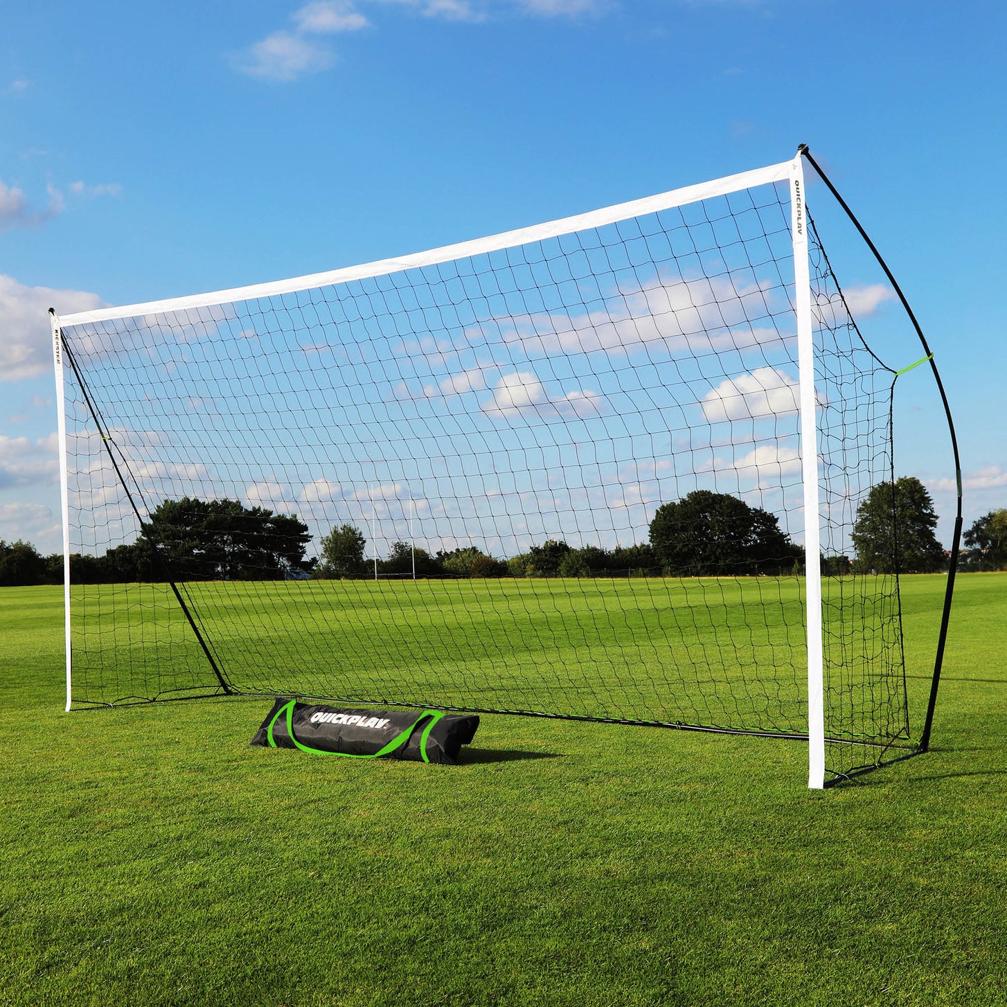 KICKSTER 18.5x6.5' goal with white posts and black net on a grass field, with its black QUICKPLAY bag at the base.