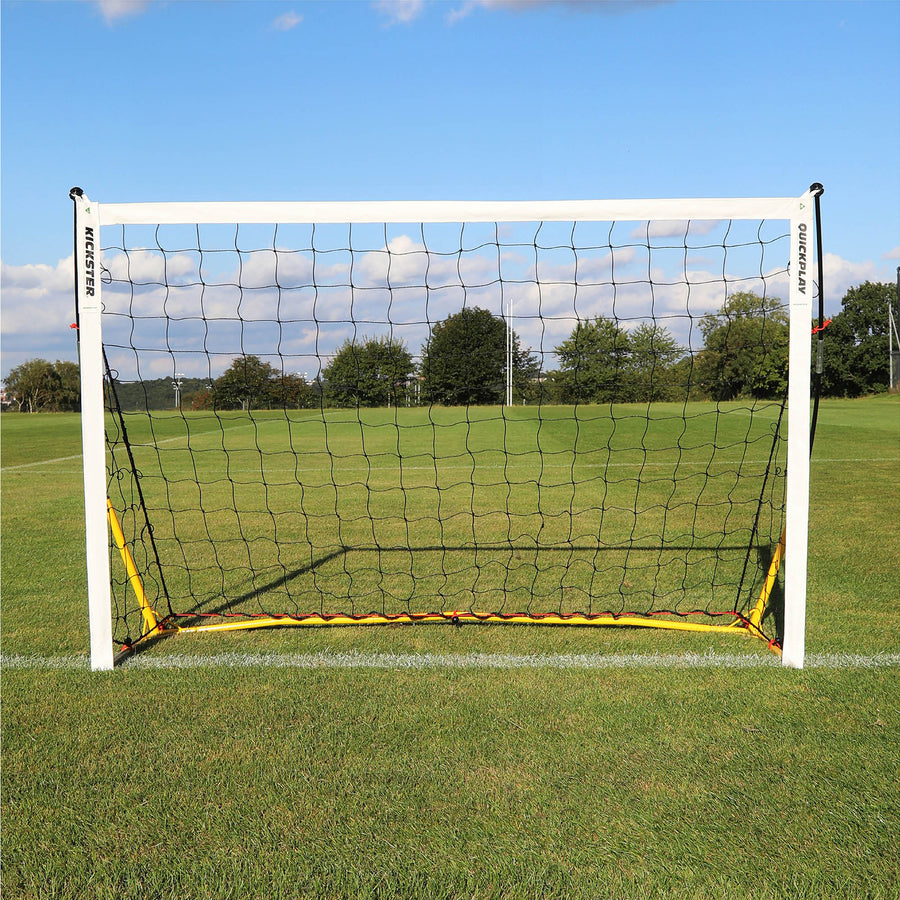 KICKSTER 6x4' (Yellow) goal from the front on a grass pitch, showing the yellow base bar and black net.