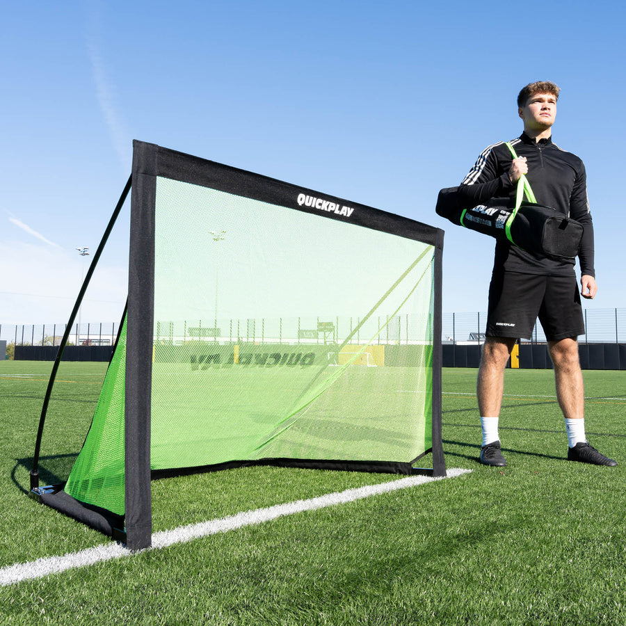 Person holding a sports training goal on a football field