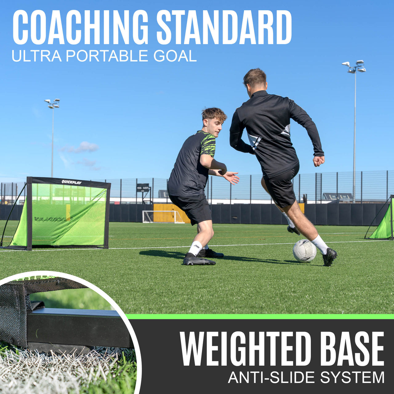 Two people playing football on a pitch with a coaching standard ultra portable goal in the background.