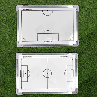 Two football coaching boards on grass with tactical diagrams.