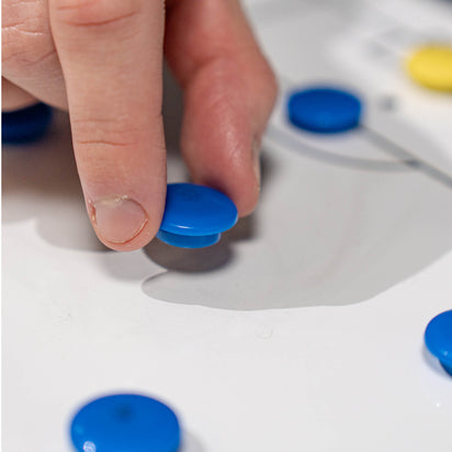 Hand interacting with blue magnets on a football tactics board