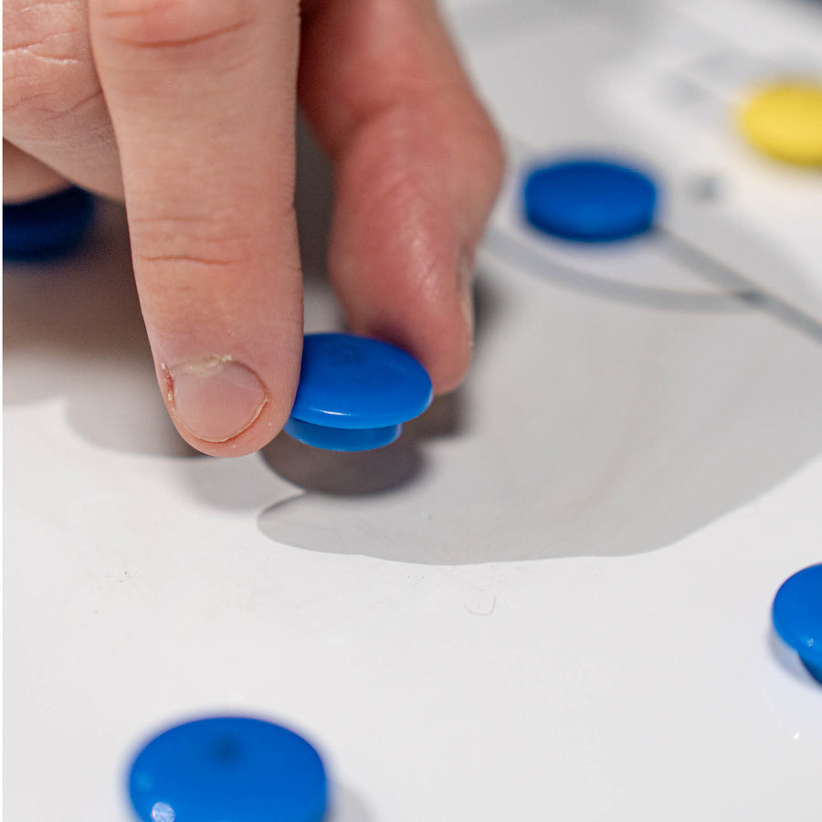 Hand interacting with blue magnets on a football tactics board