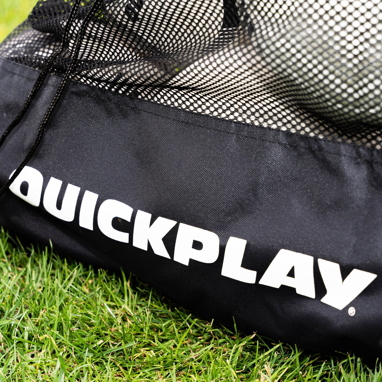 Mesh Football Bag close up: white QUICKPLAY logo on the black fabric base, with the mesh top and drawcord.