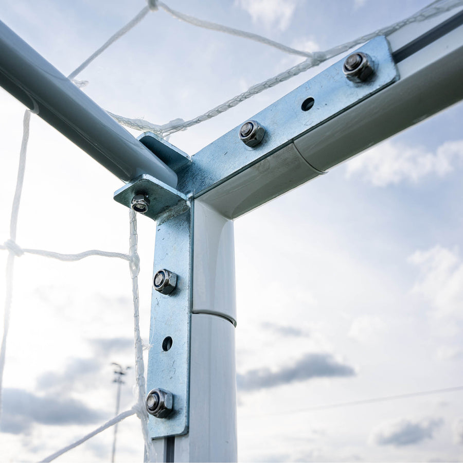 Metal football goal frame with bolts against a cloudy sky
