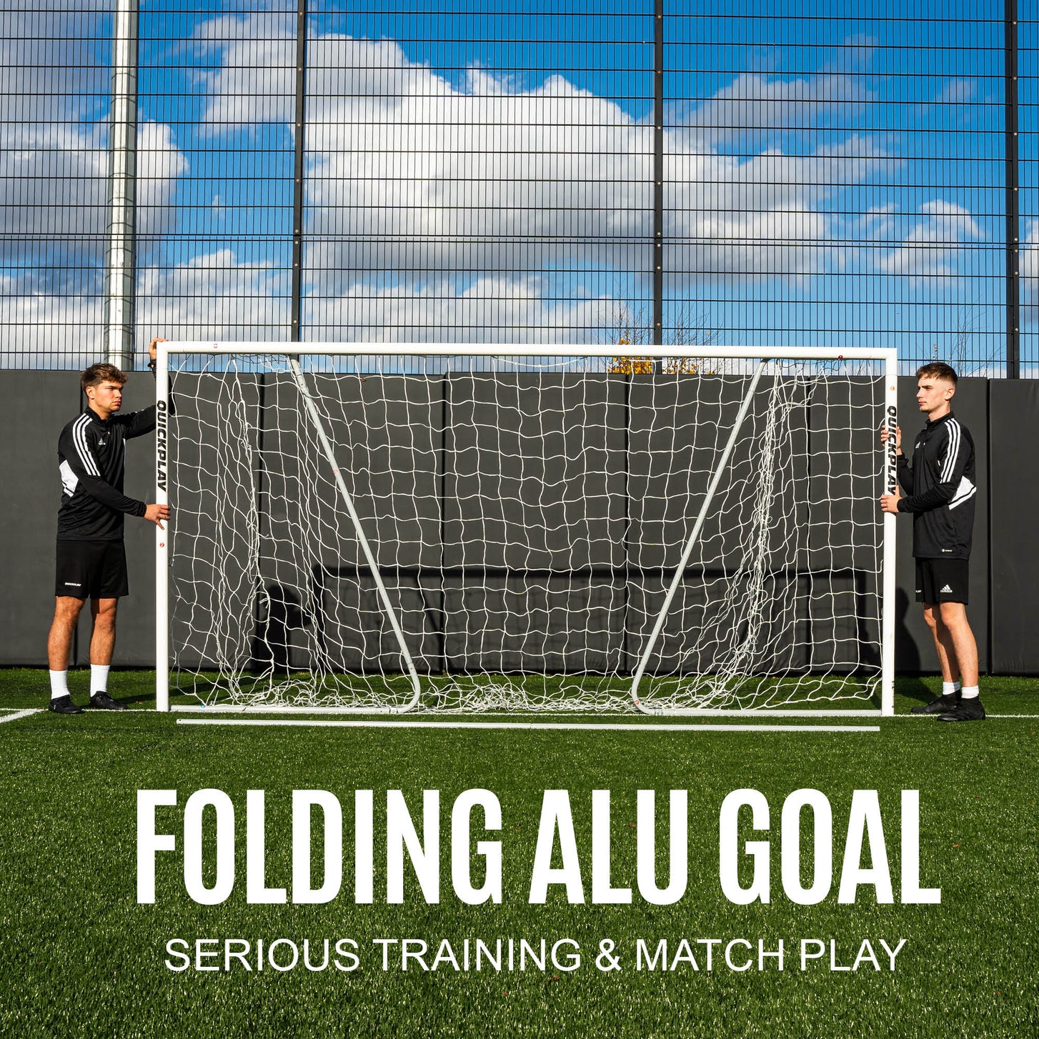 Two players holding up the folding PRO ALU Match60 Futsal Goal 3x2m at each post, with the text "Folding alu goal, serious training & match play".
