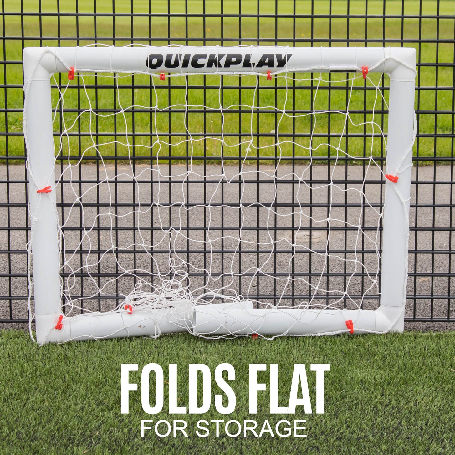 Q-FOLD Mini 3x2.5' goal folded flat against a fence, with the text "Folds flat for storage".
