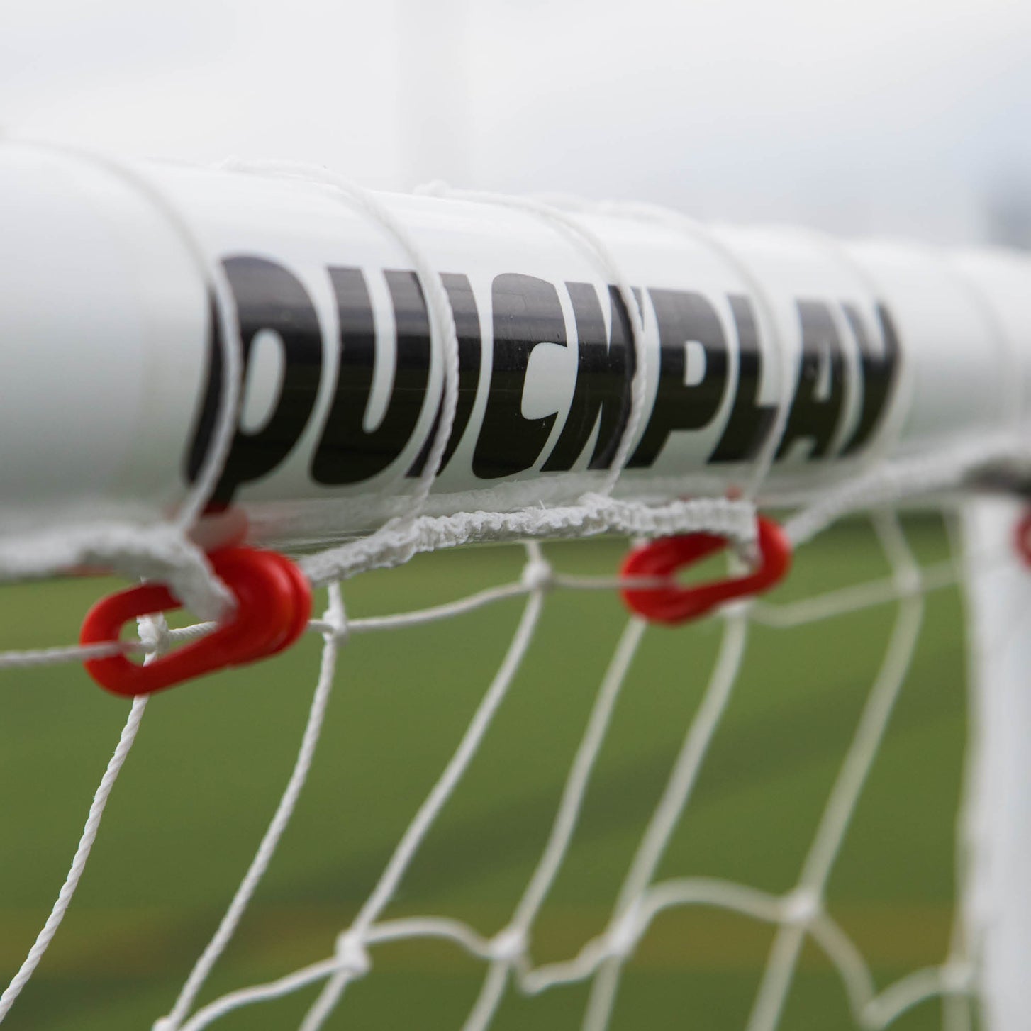 Close-up of the QUICKPLAY logo on the Q-FOLD Mini 3x2.5' crossbar, with red net clips below.