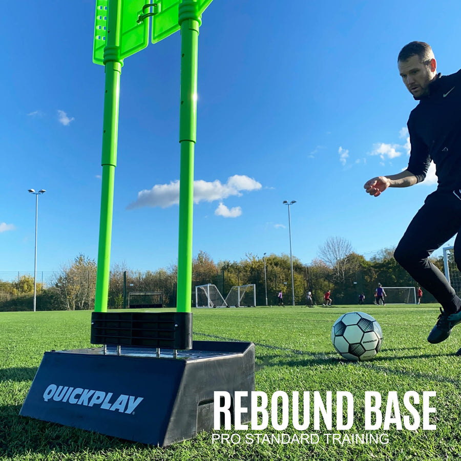Player receiving a ball rebounding off a REPLAY Defender base on an artificial pitch, with the text "Rebound base".