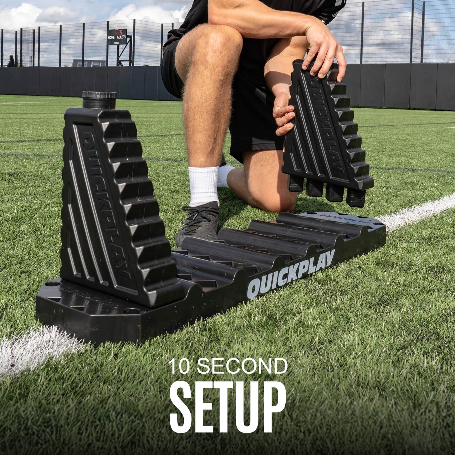 Person using a QuickPlay football rebound board on a grass field