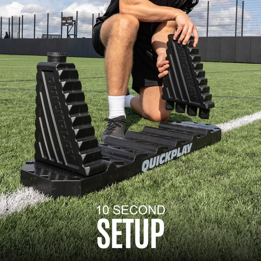 Person using a QuickPlay football rebound board on a grass field