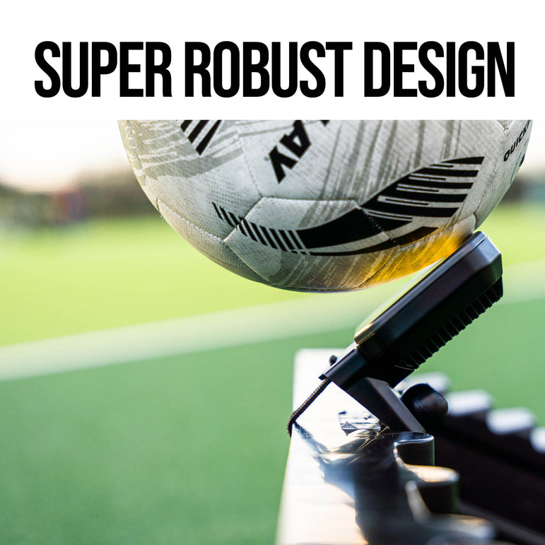football being kicked at an RXTR with 'Super Robust Design' text above it, on a blurred sports field background.