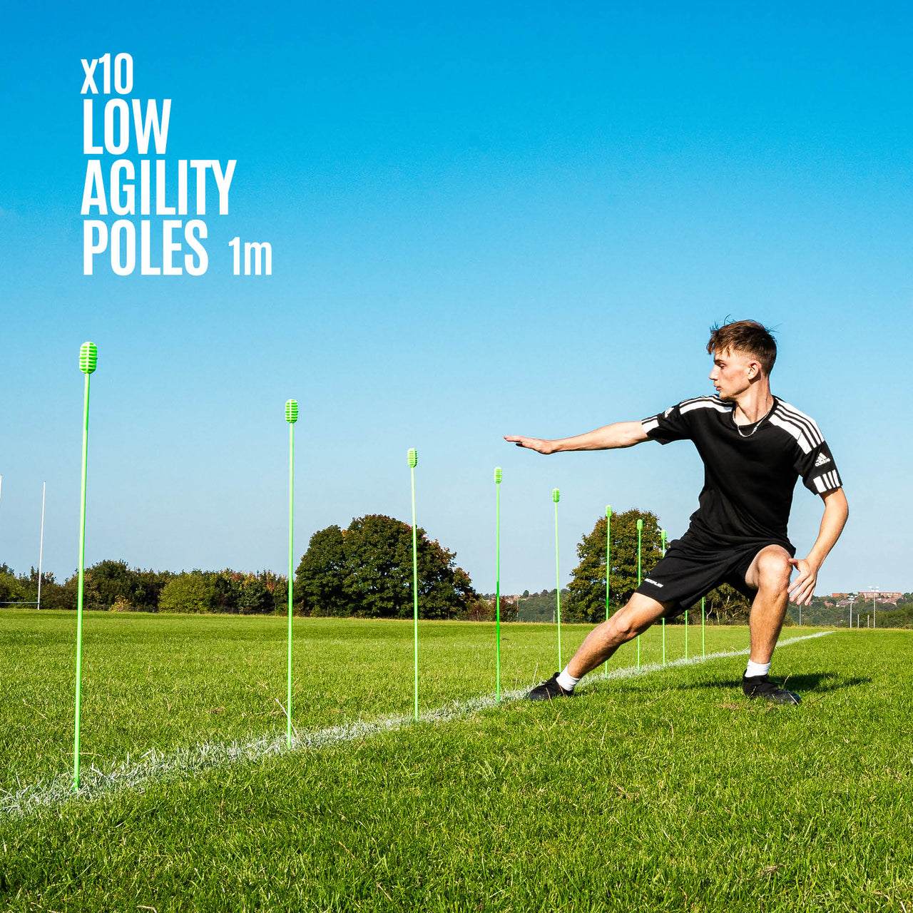 Person using agility training poles on a grass field with clear blue sky