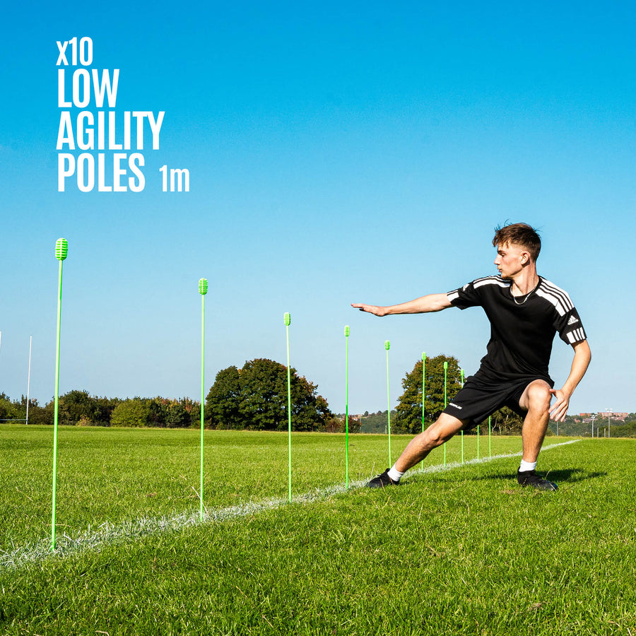 Person using agility training poles on a grass field with clear blue sky