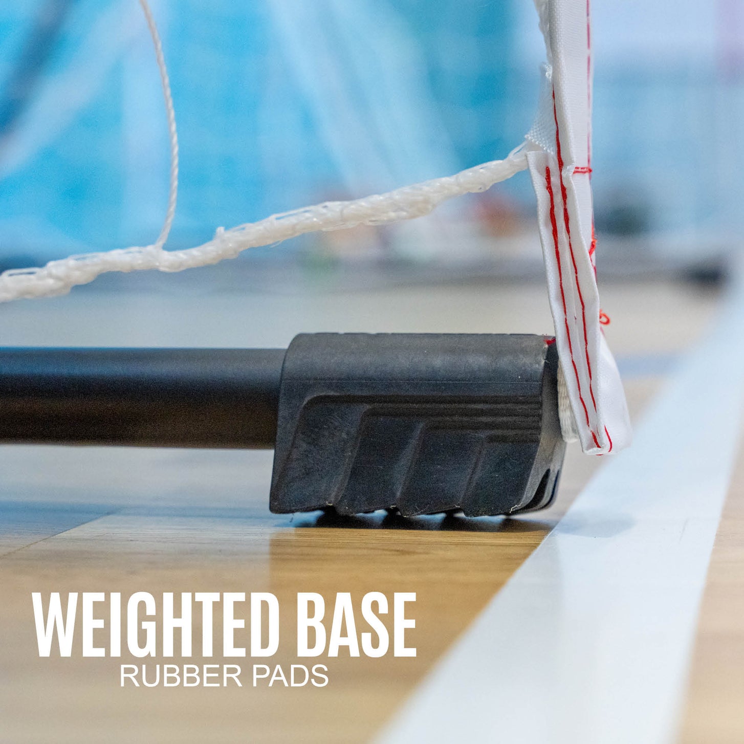 Portable Handball Goal Adult 3x2m close up of the black base and rubber pad on a hall floor, with the text "Weighted base rubber pads".