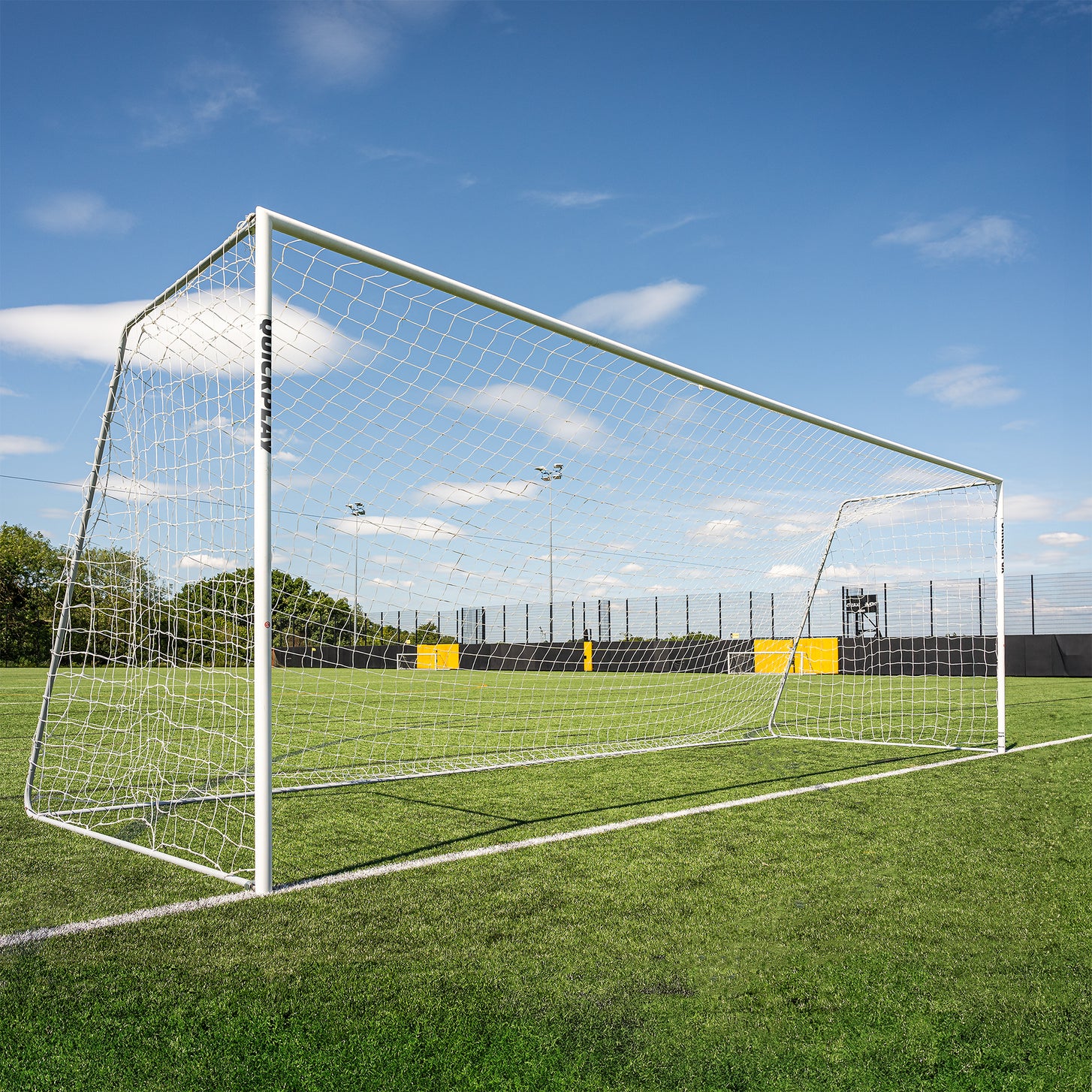 PRO ALU Match60 24x8' goal with a white frame and net, seen from the side on an artificial pitch.