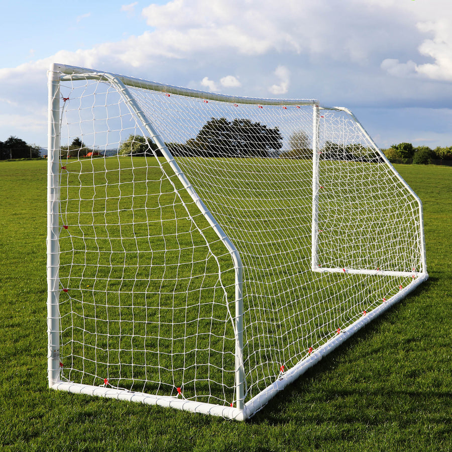 Q-FOLD Match 12x6' goal at an angle on a grass field, showing the net and rear frame.
