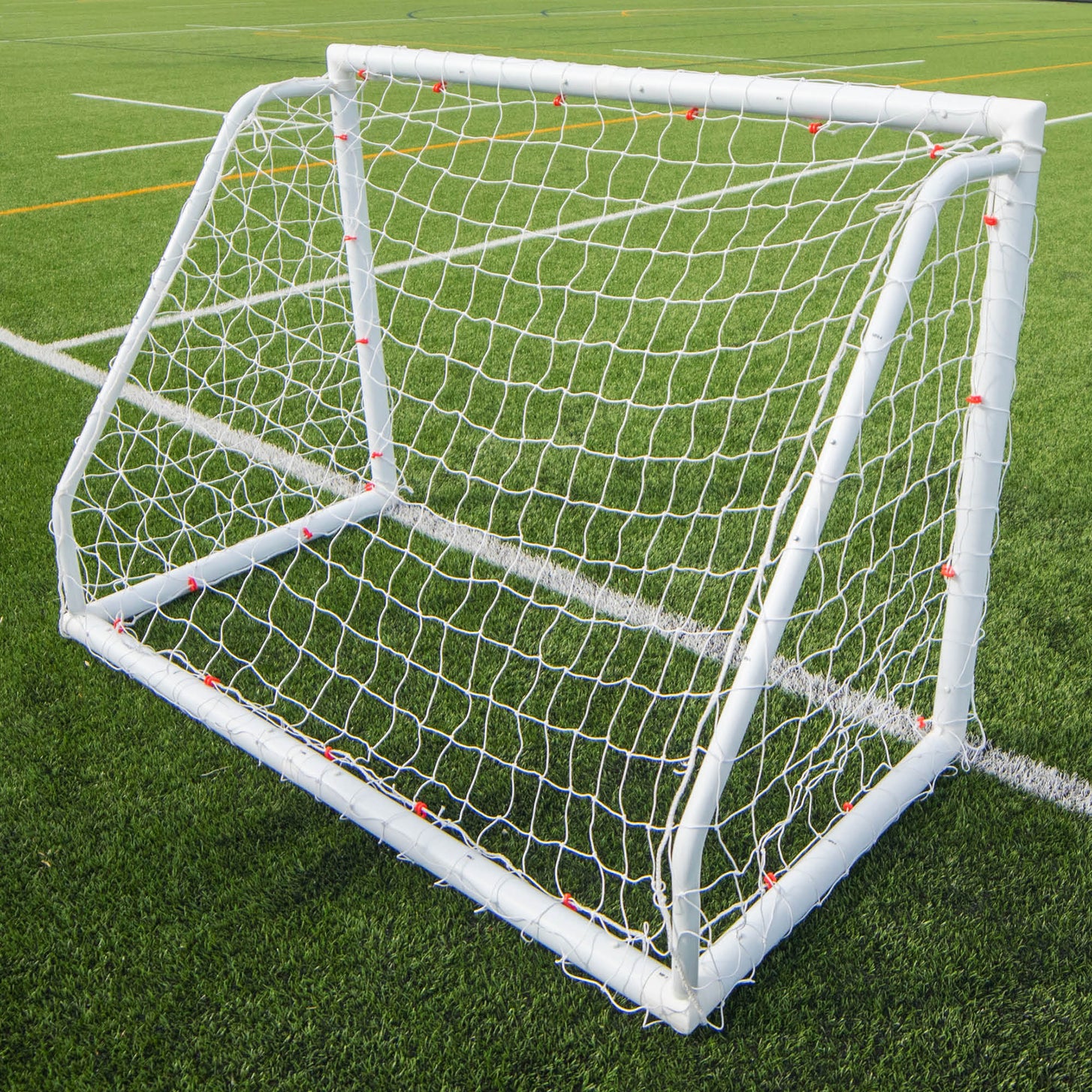 Q-FOLD Match 6x4' goal seen from behind on an artificial pitch with white and orange lines.