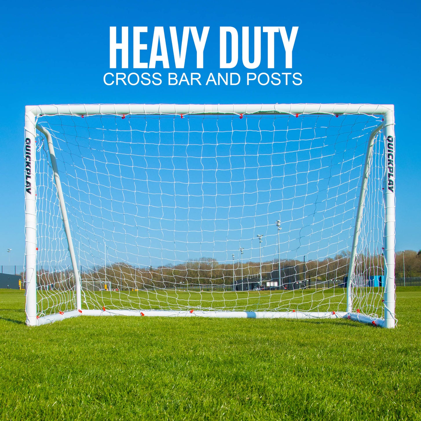 Q-FOLD Match 8x5' goal from the front on a grass pitch under a blue sky, with the text "Heavy duty cross bar and posts".