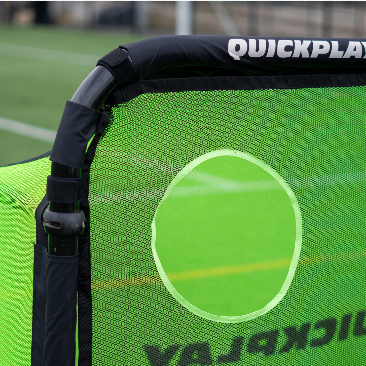 Close up of a top corner of the PRO ALU Training Target Net Lite 6x4', showing the black straps and a target hole.