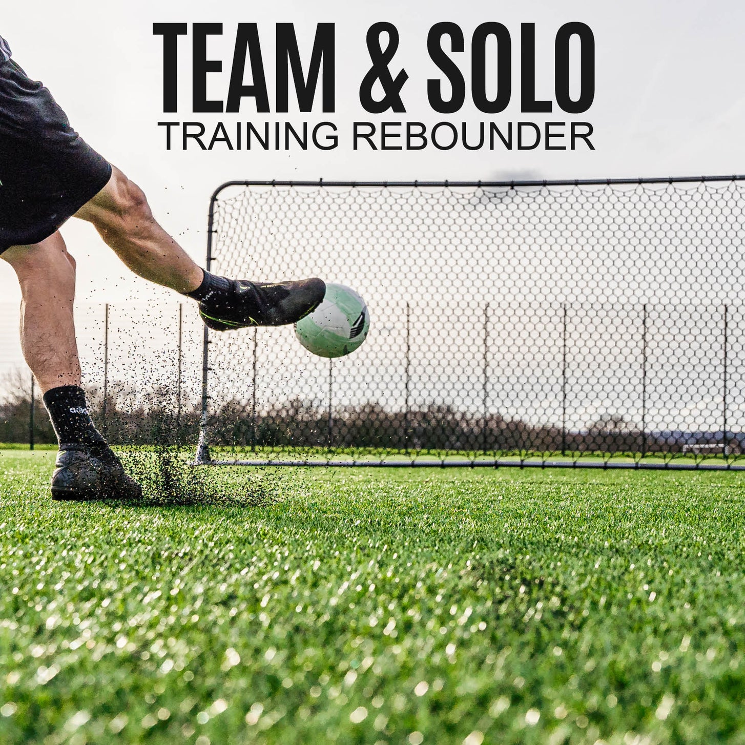 Player striking a ball at the Barrier Net & Rebounder 12x6' on artificial grass, with the text "Team & solo training rebounder".
