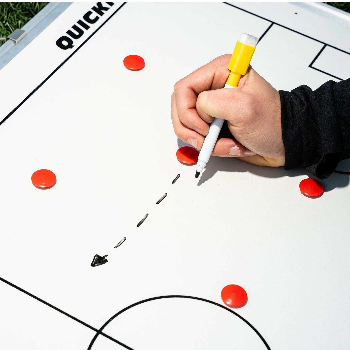 Hand drawing a dashed arrow with a yellow marker pen on the Magnetic Whiteboard (S) 30x45cm, beside red magnets.