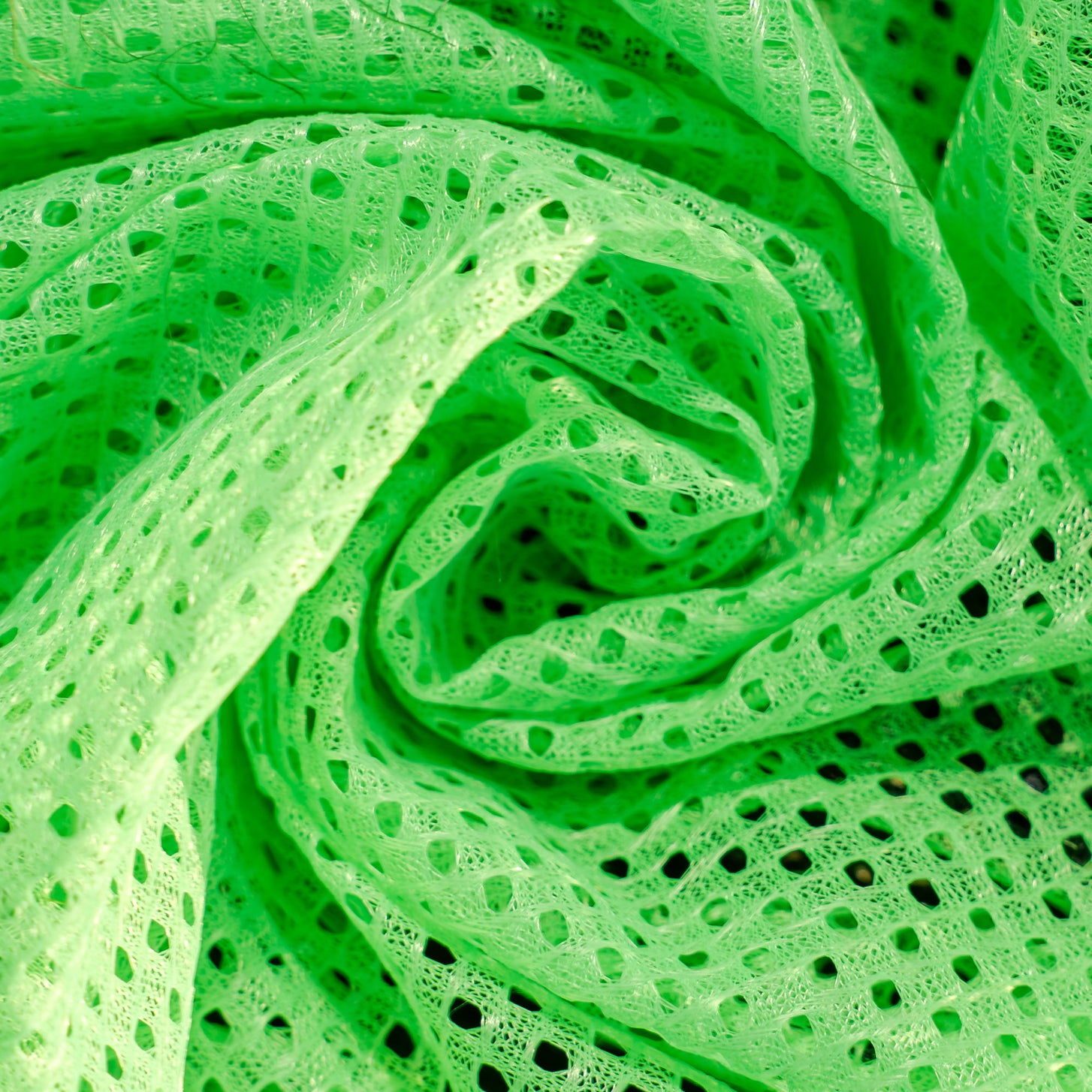 Training bibs close up of the green mesh fabric, swirled into a spiral.