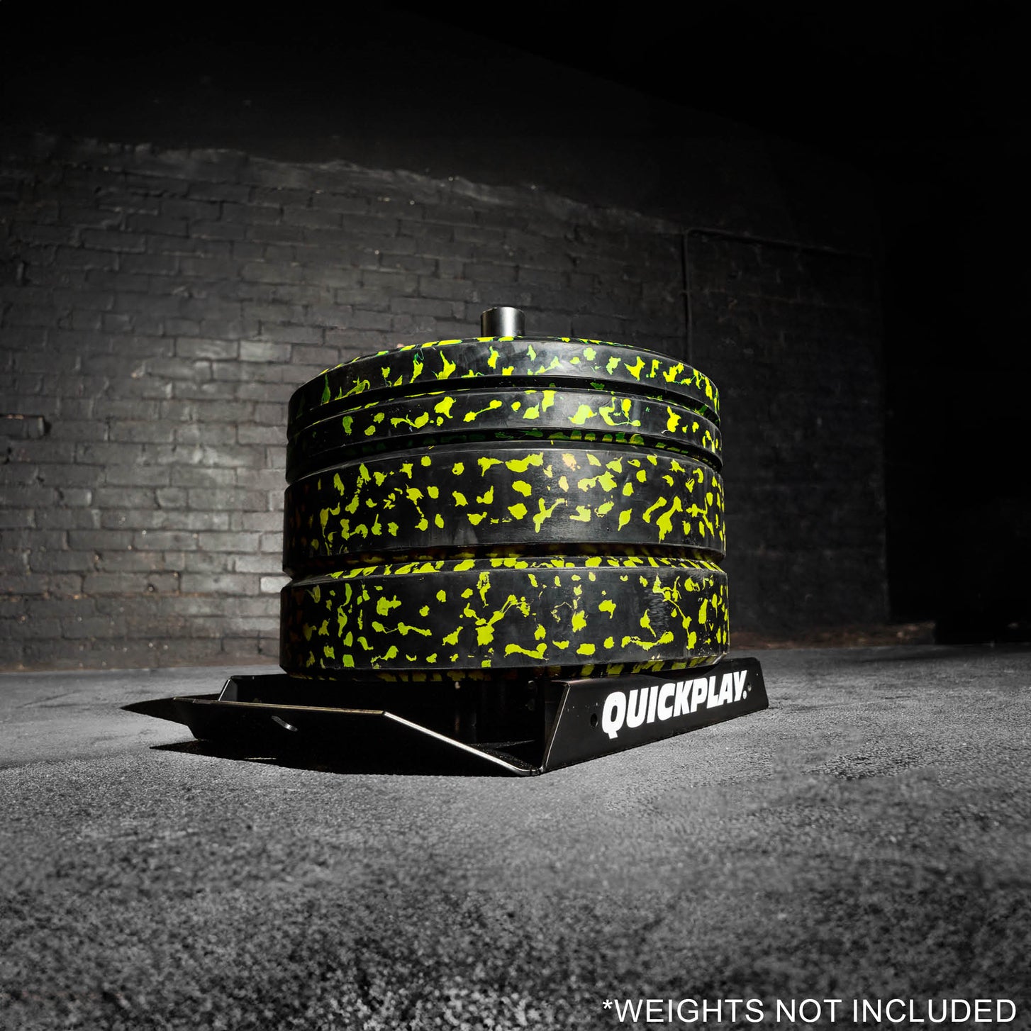 Pull Speed Sled loaded with a stack of black and yellow weight plates in a dark gym, with the text "Weights not included".