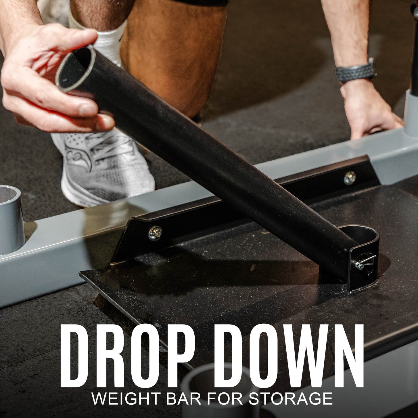 Hand folding down the weight post of the Pull Speed Sled, with the text "Drop down weight bar for storage".