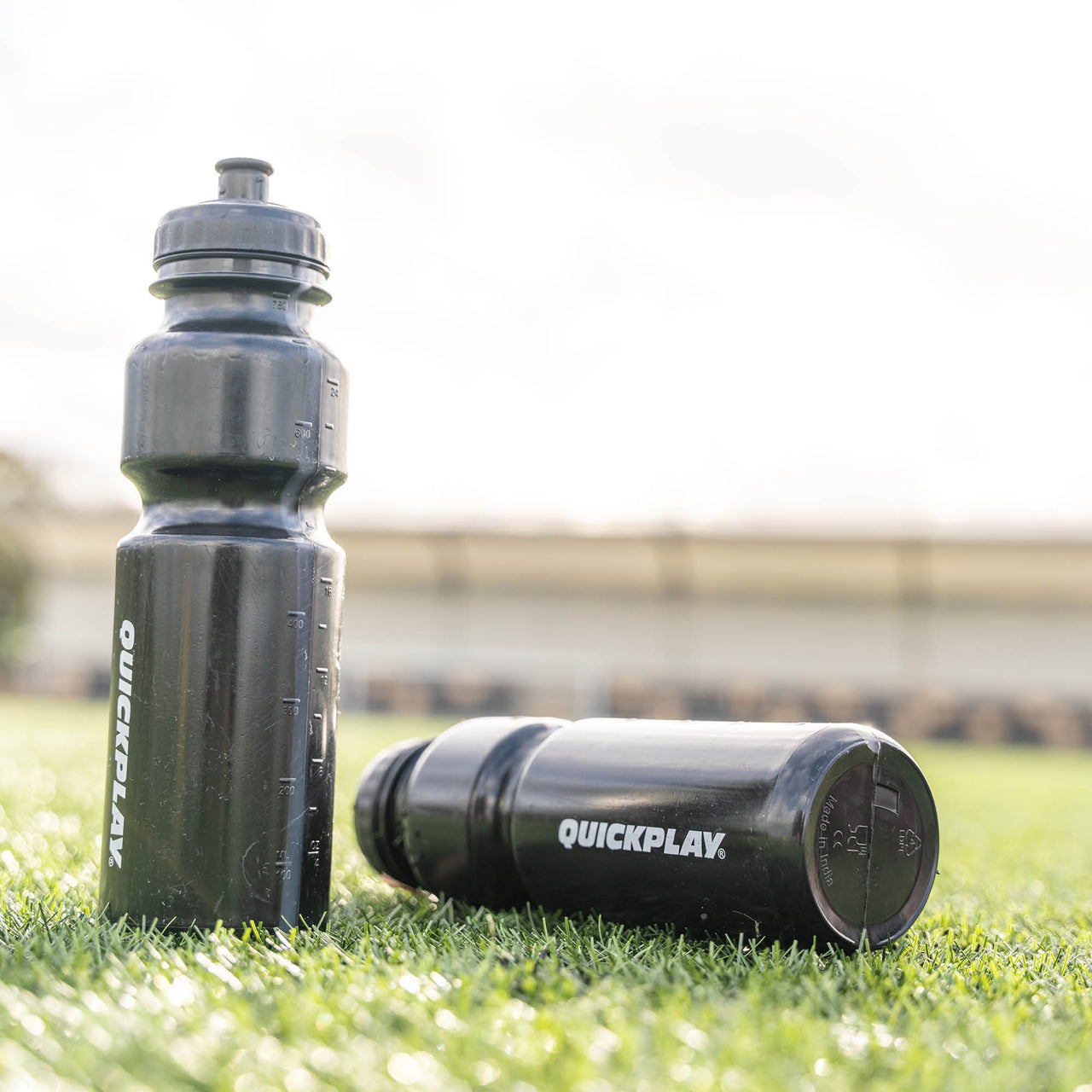 2 Black water bottles on grass with 'QuickPlay' branding