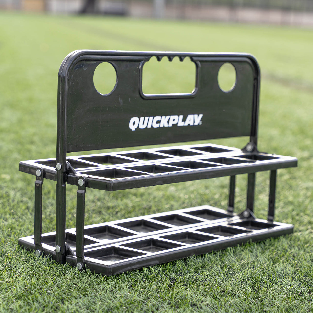 Black folding water bottle holder with 'QuickPlay' branding on grass