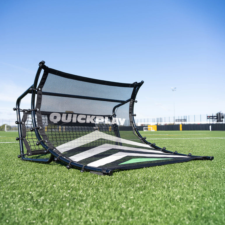 Black and white football rebounder with 'QuickPlay' branding on a grass field.