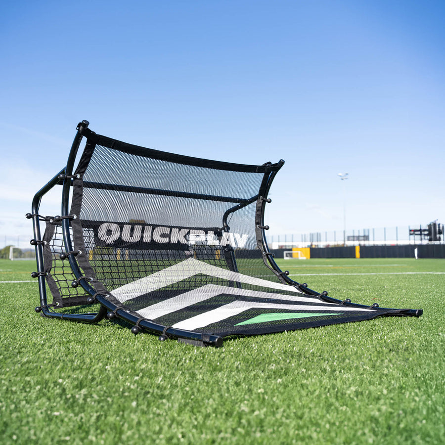 Black and white football rebounder with 'QuickPlay' branding on a grass field.