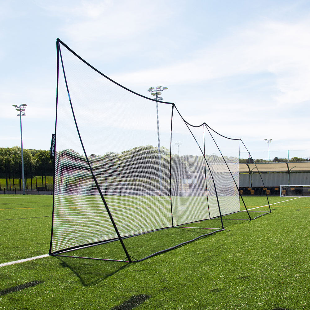 MEGA NET XL Ball-Stop 32x9' from a low side angle, showing the black frame and white net on an artificial pitch.