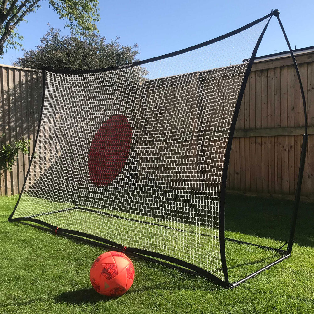 SPOT Football Rebounder 8x5' with a white net and red target circle in a garden, with an orange ball in front.